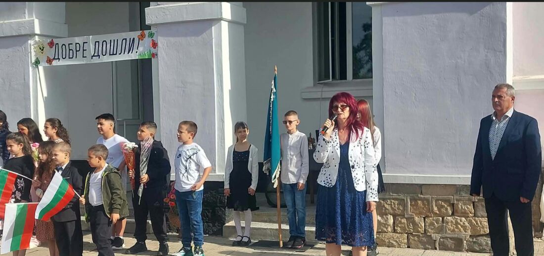 Ученици със знамена и слово пред входа с надпис „Добре дошли“